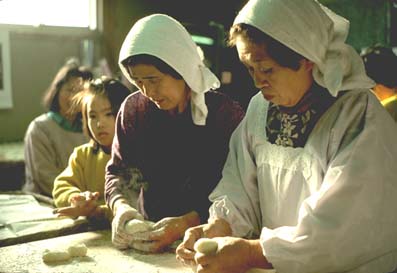 photo of several women shaping rice cakes