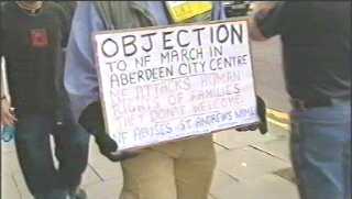 Placard reads: OBJECTION to NF March in Aberdeen City Centre. NF attacks human rights of families they don't welcome. NF abuses St. Andrew's name.