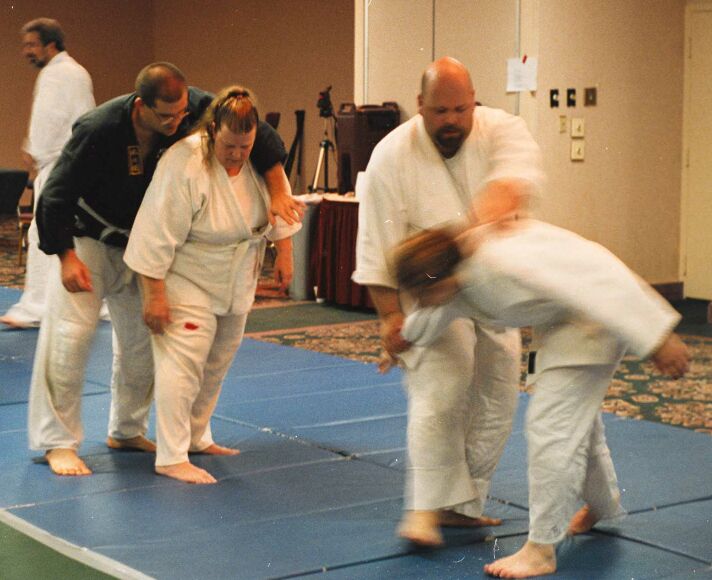 AJ throws Martin in the background while Sean gets ready to throw Angie
