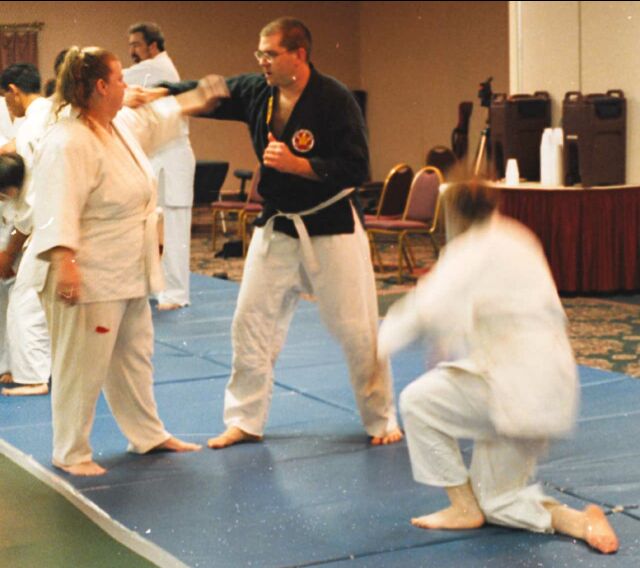 Martin throws AJ while a blurry Angie gets back on her feet.