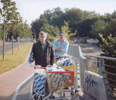 Click to enlarge! Ich mit einer #0099FF-farbenen Selters-Flasche in der Hand, satyrisch l�chelndem Flaschensammler und Einkaufswagen am 23. Juni 2004 gegen 7 Uhr 40 Minuten auf der Modersohn-Br�cke.