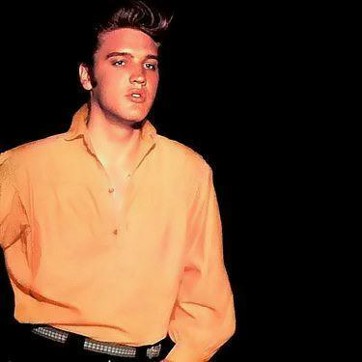 A young Elvis wearing an orange shirt.