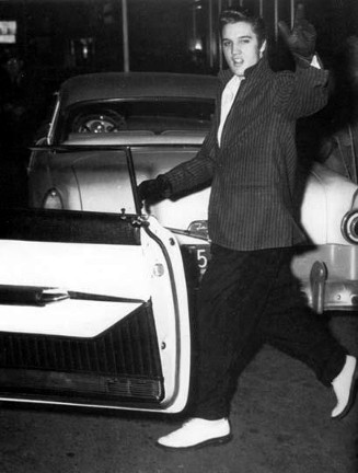 1950s Elvis waving as he gets in car.