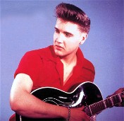 A young Elvis poses with his guitar.