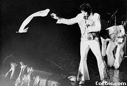 Elvis throwing a scarf to a fan in 1977