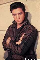 Elvis standing against a wall