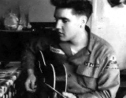 Elvis taking time out to play the guitar during his time in the army.