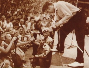 Elvis leaning over stage during 1950s concert