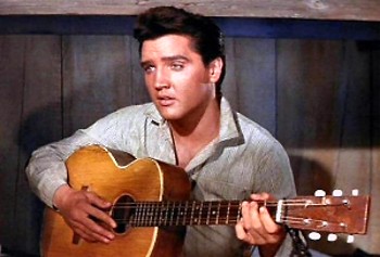 Elvis holding his guitar.