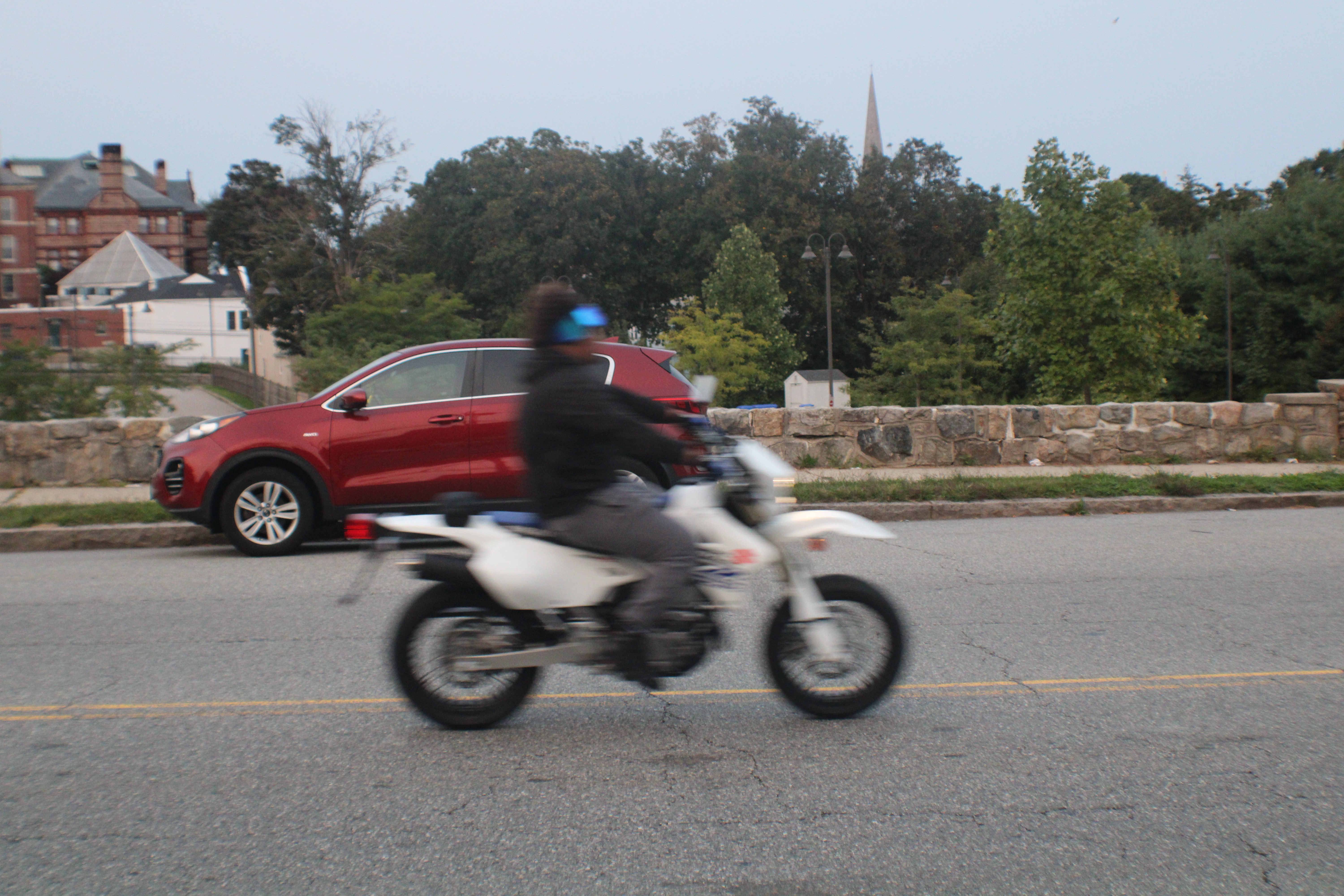 A man speeding by on a motor cycle
