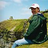 James with his feet hanging over the edge at the Cliffs of Moher, County Clare