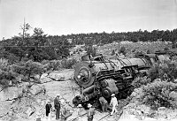 ATSF RR TRAIN WRECK S OF GRAND CANYON VILLAGE. THE TRAIN WAS A DOUBLE-HEADER AND<br>THE TWO ENGINES LEFT THE RAILS ON A CURVE IN THE CUT, LODGING UP AGAINST THE SOLID STONE EMBANKMENT ON THE OUTSIDE OF THE CURVE. <br>27 JUL 1939 NPS PHOTO.