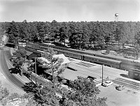 LOOKING SE AT THE LONGEST TRAIN TO HAVE ENTERED GRAND CANYON, THE ELKS SPECIAL, TAKEN FROM THE EL TOVAR HOTEL. DEPOT IN FORGROUND. 05 JULY 1956. NPS PHOTO BY LEDING. 