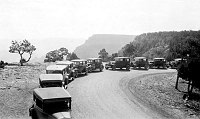LINE OF 10 AUTOMOBILES PARKED NEAR THE RIM AT YAVAPAI POINT. DOG WAITING INSIDE CENTER AUTO. CIRCA 1929. NPS.
