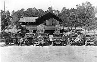 6 CARS & 20 PARK EMPLOYEES STANDING IN FRONT OF THE ORIGINAL OPERATIONS / ADMINISTRATION BUILDING. (BUILDING 1) CIRCA 1921. NPS<br>
