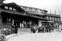 VISITORS STANDING AROUND THE FRONT ENTRANCE  TO THE EL TOVAR HOTEL. HOPI DEMONSTRATORS POSING. TOUR AUTOMOBILE. CIRCA 1922. FRED HARVEY PHOTO.