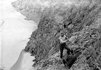 TRANS-CANYON TELEPHONE LINE CONSTRUCTION - 2 CCC ENROLLEES DRIVING STAKE ON VISHNU SHIST LEDGE ABOVE THE COLORADO RIVER. CIRCA 1935 <br><br>