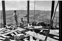 INSIDE WATCHTOWER DURING CONSTRUCTION SHOWING TOWER FRAMEWORK. 2 WORKMEN - CANYON BEHIND. CIRCA 1932. COLTER. 