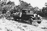 FLAT-BED TRUCK LOADED W/ ROCKS. ROPE COIL ATTACHED TO CAB. WATCHTOWER CONSTRUCT. CIRCA 1932, HIRCHBORN