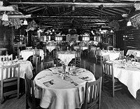 INTERIOR, EL TOVAR DINING ROOM LOOKING S. PINE BOUGH GARLANDS. TABLES SCATTERED. CIRCA 1910 - 1920. FRED HARVEY PHOTO.