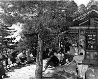 ASST. PARK NATURALIST ERNST CHRISTENSEN ABOUT TO LEAD A NATURE WALK ON THE NORTH RIM. VISITORS SITTING BY THE N RIM KIOSK NEAR GRAND CANYON LODGE. 23 JUNE 1949 NPS PHOTO BY EDEN.