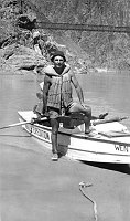 NORMAN NEVILLS, THE FIRST TO RUN COMMERCIAL RIVER TRIPS THROUGH THE GRAND CANYON, UPON ARRIVAL AT THE MOUTH OF BRIGHT ANGEL CREEK. THE BOAT WEN IS ON ITS 5TH CANYON TRIP. (BLACK BRIDGE BEHIND) JULY 1947. NPS, EDEN. 
