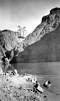 RUST CABLE & TRAMWAY CAR OVER COLORADO RIVER. MAN SITTING ON SHORE WITH SMALL CANVAS BOAT (BENEATH CABLE.) CIRCA 1911. RUST COLLECTION.