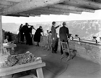 NATURALIST EDWIN MCKEEE SHOWS THE CANYON TO VISITORS AT YAVAPAI OBSERVATION STATION. CIRCA 1930. NPS. <br><br>