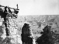 MAN STANDING ON A PILLAR OF KAIBAB LIMESTORE ON THE RIM OF THE CANYON NEAR GRANDVIEW POINT. GRCA 147738. CIRCA 1899. PEABODY.