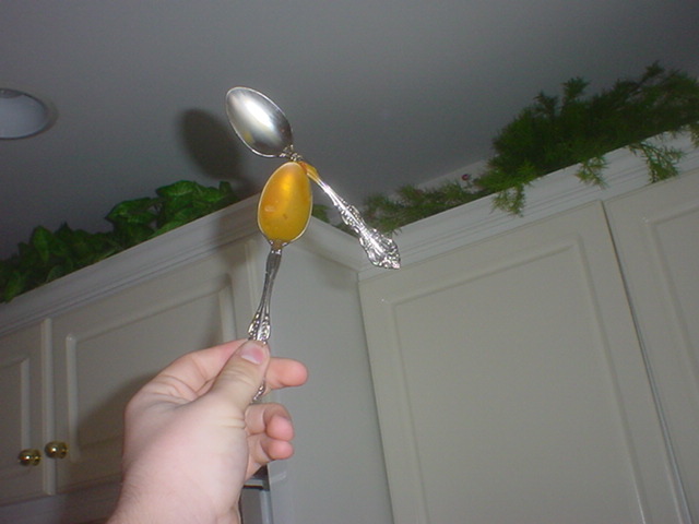 Two spoons glued together with old nacho cheese.