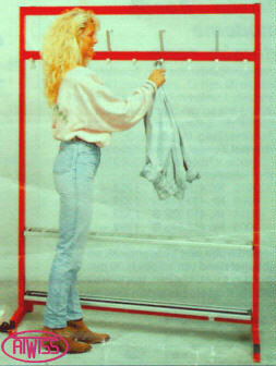 A Tall model next to a clothing rack.