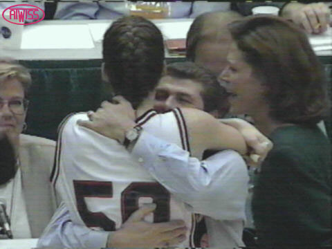 Coach, hugged by female basketball player