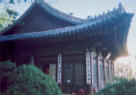 The golden Buddha, inside, is lit by votive lamps and candles.