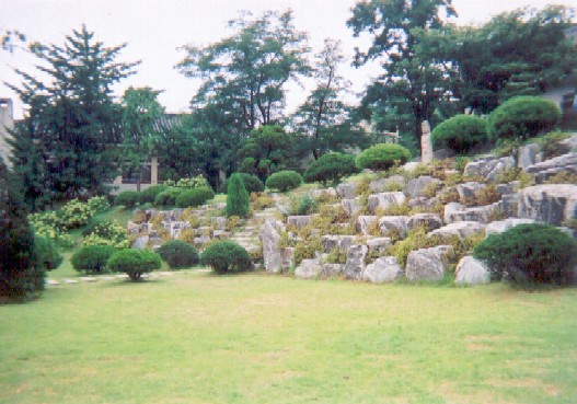 Rock garden and lawn in front of Buddhist temple.