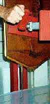 Photo of the press in use whichshows the honey streaming down from the press plates
