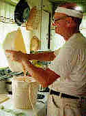 Photo of me straining honeythrough a knee-high hose into a bucket