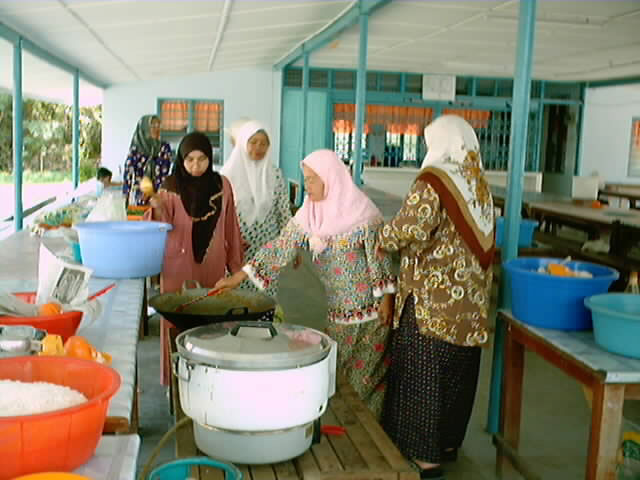 guru dan pekerja sekolah sibuk menyediakan makanan - goreng ikan