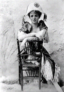 Maude Adams seated in chair wearing hat