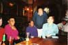 Seated: member Tony (BS), non member Lidiane, members Val and Nigel (SOS). In background: other members.