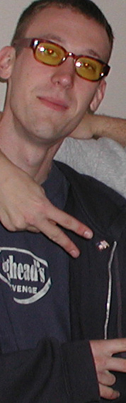 this is Ryan, who usually has hair sharp enough to give you a fatal wound. He enjoys the musical stylings of the Vandals, Weezer, Bob Marley and Social Distortion, among others. He's also an avid fan of Spongebob Squarepants, one of the great comic geniuses of our time. Which reminds me of this time at Worlds of Fun when I saw two guys walking around wearing the same Spongebob t-shirt. The scary thing was that they were walking around together. Wearing the same damn thing. I wanted to slap both of them. Wait, I did slap both of them. That was fun. Anyway, Ryan and I were both victims f the International Baccalaureate program in high school, which you should not take even under threat of severe dismemberment. Through Ryan I have learned that Nixon was actually our friend while Ronnie Reagan is the Great White Devil. Click here to see a rare pic of emoy without his glasses. Scary.