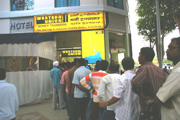 Foreign workers queuing up to remit money home outside a Western Union shop in Serangoon