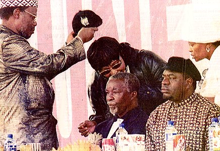 Mangusotho replaces Winnie's cap after it was intentionally knocked off by Thabo. Sam peers into the far distance.