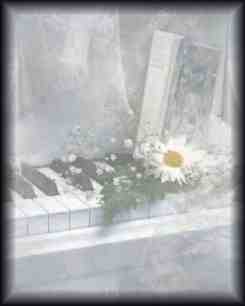 photo of a piano with flowers and a book on it