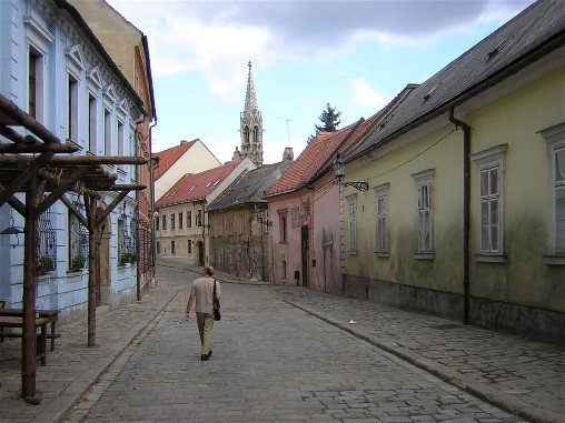 crumbing buildings and a crumbling man on Kapitulska. The spire of Sv Klara is in the background.