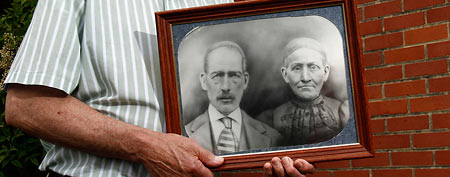 Jack Goins with an 1898 portrait of his step-great-great grandfather, George Washington Goins, and great-great grandmother, Susan Minor-Goins (AP/Wade Payne)