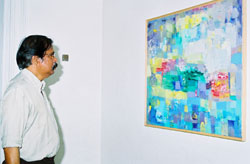 E. Harikumar in front of a Damodaran Painting