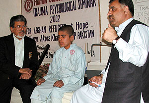 Arshad Husain, talks to a child in the refugee camp