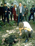 Scully y el equipo de polic�as de la zona observan a Mulder junto al cad�ver