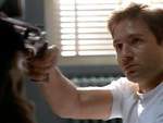Mulder, impedido de controlar su voluntad, la apunta a Scully