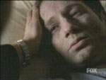 Scully acaricia a Mulder, que acaba de recuperar la conciencia